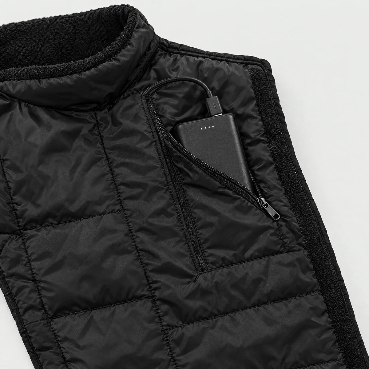Power bank in the zippered pocket of the neck & chest warmer, connected to the USB cable